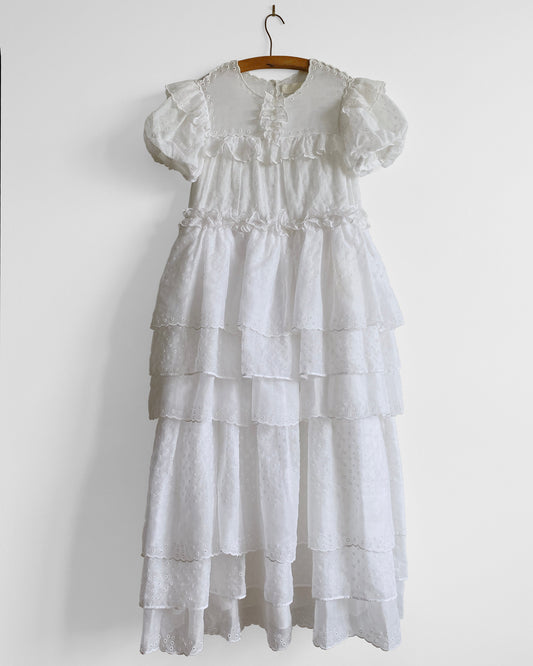 White tiered dress on a hanger against a white background