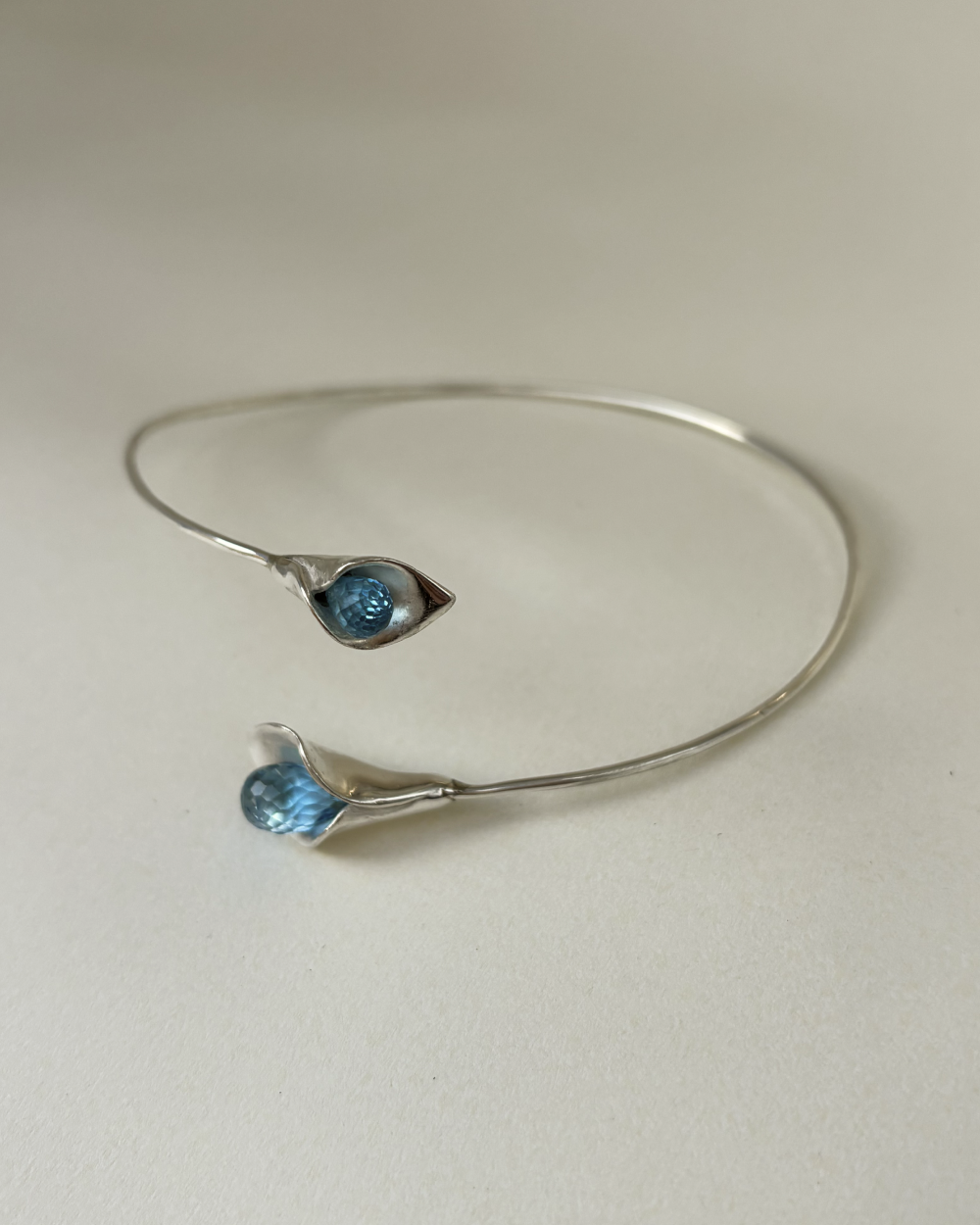 Silver bracelet with blue gemstones on a light gray background