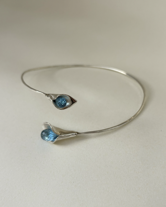 Silver bracelet with blue gemstones on a light gray background